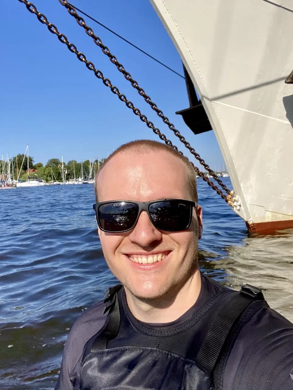 Jan on the water in front of a sailing ship